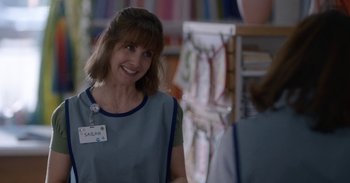 Movie still from “Horse Girl” (2020), directed by Jeff Baena – A woman smiling for the camera while wearing an apron; Close Up shot, Over the shoulder angle
