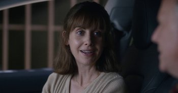 Movie still from “Horse Girl” (2020), directed by Jeff Baena – A person smiling for the camera; Close Up shot, Over the shoulder angle