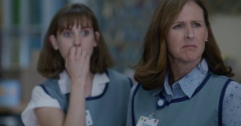 Movie still from “Horse Girl” (2020), directed by Jeff Baena – A woman with her hand to her face and a woman with her hand to her mouth; Close Up shot, Over the shoulder angle