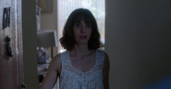 Movie still from “Horse Girl” (2020), directed by Jeff Baena – A woman standing in a room with a window in the background; Close Up shot, Over the shoulder angle