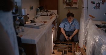 Movie still from “Horse Girl” (2020), directed by Jeff Baena – A man sitting on the floor of a bathroom; Medium shot, High angle