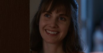 Movie still from “Horse Girl” (2020), directed by Jeff Baena – A woman smiling for the camera; Close Up shot, Over the shoulder angle