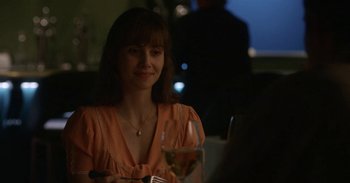 Movie still from “Horse Girl” (2020), directed by Jeff Baena – A woman sitting at a table with a glass of wine in front of her; Close Up shot, Over the shoulder angle