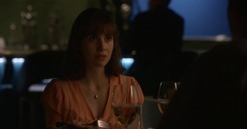 Movie still from “Horse Girl” (2020), directed by Jeff Baena – A woman sitting at a table with a glass of wine; Close Up shot, Over the shoulder angle