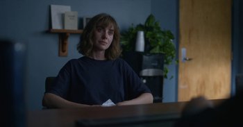 Movie still from “Horse Girl” (2020), directed by Jeff Baena – A woman sitting at a table in front of a computer; Medium shot, Over the shoulder angle