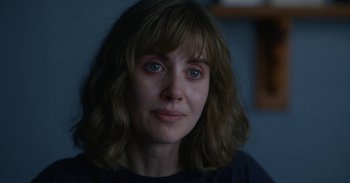 Movie still from “Horse Girl” (2020), directed by Jeff Baena – A person wearing a black t - shirt; Close Up shot, Over the shoulder angle