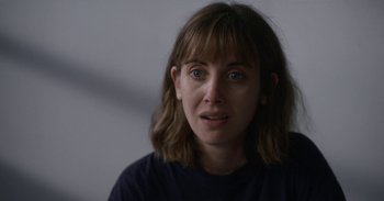 Movie still from “Horse Girl” (2020), directed by Jeff Baena – A person wearing a black t - shirt; Close Up shot, Over the shoulder angle