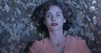 Movie still from “Horse Girl” (2020), directed by Jeff Baena – A woman laying on the ground looking at the camera; Close Up shot, Overhead angle