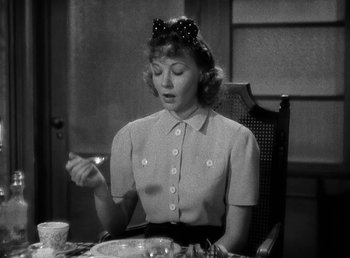 Movie still from “The Bank Dick” (1940), directed by Edward F. Cline – A woman sitting at a table with a plate in front of her; Close Up shot, High angle