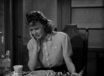 Movie still from “The Bank Dick” (1940), directed by Edward F. Cline – A woman sitting at a table with a plate of food in front of her; Close Up shot, High angle