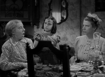 Movie still from “The Bank Dick” (1940), directed by Edward F. Cline – A group of people sitting around a table; Medium shot, Over the shoulder angle
