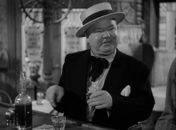 Movie still from “The Bank Dick” (1940), directed by Edward F. Cline – An older man wearing a suit and a straw hat; Medium shot, Low angle