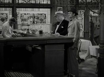 Movie still from “The Bank Dick” (1940), directed by Edward F. Cline – Two men standing at a counter in front of a bar; Wide shot, High angle
