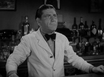 Movie still from “The Bank Dick” (1940), directed by Edward F. Cline – An older man wearing a white jacket and a bow tie; Medium shot, Low angle
