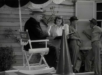 Movie still from “The Bank Dick” (1940), directed by Edward F. Cline – A man and a woman sitting on a chair; Medium shot, Over the shoulder angle