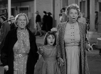 Movie still from “The Bank Dick” (1940), directed by Edward F. Cline – A group of people standing next to each other on a sidewalk; Medium shot, Low angle