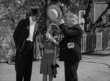 Movie still from “The Bank Dick” (1940), directed by Edward F. Cline – A group of people standing next to each other on a street; Medium shot, Over the shoulder angle
