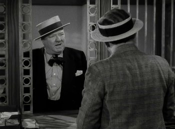 Movie still from “The Bank Dick” (1940), directed by Edward F. Cline – An old photo of a man looking in the mirror; Medium shot, Over the shoulder angle