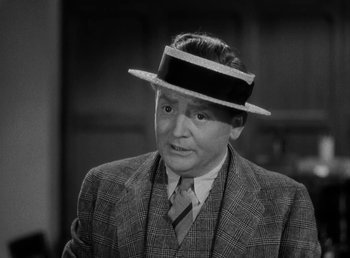 Movie still from “The Bank Dick” (1940), directed by Edward F. Cline – A man wearing a suit and a hat; Close Up shot, High angle