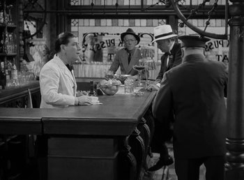 Movie still from “The Bank Dick” (1940), directed by Edward F. Cline – A black and white photo of people sitting at a table; Wide shot, High angle