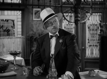 A black and white photo of a man sitting at a table