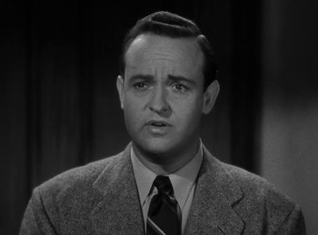 Movie still from “The Bank Dick” (1940), directed by Edward F. Cline – A man in a suit and tie in a black and white photo; Close Up shot, Low angle