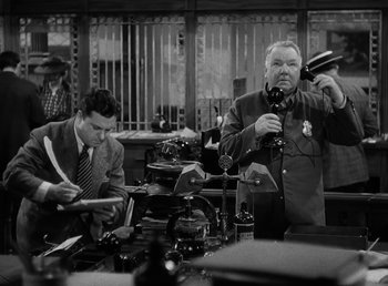 Movie still from “The Bank Dick” (1940), directed by Edward F. Cline – Two men in suits and ties in front of a window; Medium shot, High angle