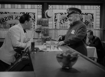 Movie still from “The Bank Dick” (1940), directed by Edward F. Cline – Two men are sitting at a bar talking to each other; Medium shot, High angle