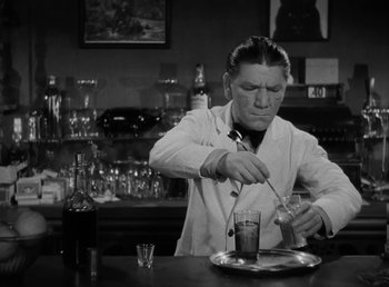 Movie still from “The Bank Dick” (1940), directed by Edward F. Cline – A man in a white lab coat stirring a glass of liquid; Medium shot, Low angle