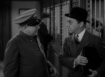 Movie still from “The Bank Dick” (1940), directed by Edward F. Cline – Two men in military uniforms talking to each other; Medium shot, Over the shoulder angle