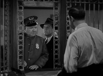 Movie still from “The Bank Dick” (1940), directed by Edward F. Cline – Two men are looking at each other in a mirror; Medium shot, Over the shoulder angle