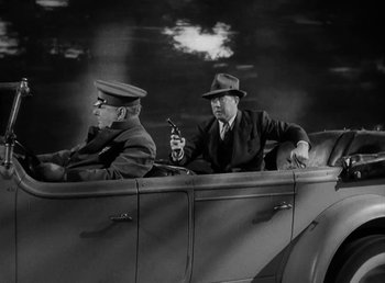 Movie still from “The Bank Dick” (1940), directed by Edward F. Cline – A couple of men sitting in the back of a truck; Wide shot, Low angle