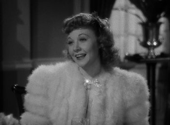 Movie still from “The Bank Dick” (1940), directed by Edward F. Cline – A black - and - white photo of a woman wearing a fur coat; Close Up shot, Over the shoulder angle
