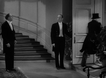 Movie still from “The Bank Dick” (1940), directed by Edward F. Cline – A man standing in front of an open door; Wide shot, High angle
