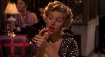 Movie still from “The Barefoot Contessa” (1954), directed by Joseph L. Mankiewicz – A woman with red lipstick looking in a mirror; Close Up shot, Over the shoulder angle