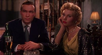 Movie still from “The Barefoot Contessa” (1954), directed by Joseph L. Mankiewicz – A man and a woman sitting at a table; Close Up shot, Low angle