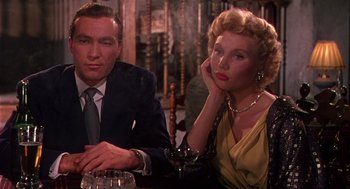 Movie still from “The Barefoot Contessa” (1954), directed by Joseph L. Mankiewicz – A man and a woman sitting at a table; Medium shot, Low angle