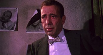 Movie still from “The Barefoot Contessa” (1954), directed by Joseph L. Mankiewicz – A person wearing a suit and a bow tie; Close Up shot, Over the shoulder angle