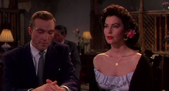 Movie still from “The Barefoot Contessa” (1954), directed by Joseph L. Mankiewicz – A man and a woman sitting at a dinner table; Medium shot, Over the shoulder angle
