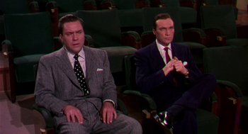 Movie still from “The Barefoot Contessa” (1954), directed by Joseph L. Mankiewicz – A couple of men in suits sitting next to each other; Medium shot, High angle