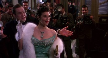 Movie still from “The Barefoot Contessa” (1954), directed by Joseph L. Mankiewicz – A woman in a blue dress and a white fur coat; Medium shot, Over the shoulder angle