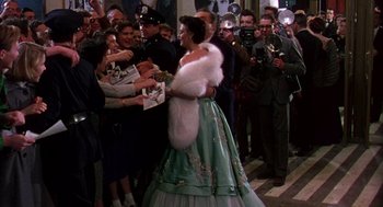 Movie still from “The Barefoot Contessa” (1954), directed by Joseph L. Mankiewicz – A woman dressed in a long dress and a white fur stole; Wide shot, High angle
