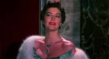 Movie still from “The Barefoot Contessa” (1954), directed by Joseph L. Mankiewicz – A woman in a green dress and a necklace; Close Up shot, Low angle