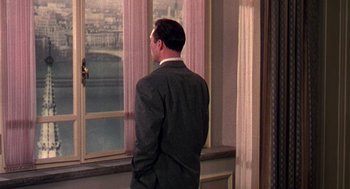 Movie still from “The Barefoot Contessa” (1954), directed by Joseph L. Mankiewicz – A man in a suit looking out a window; Medium shot, Over the shoulder angle