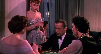 Movie still from “The Barefoot Contessa” (1954), directed by Joseph L. Mankiewicz – A man in a suit and a woman in a dress are playing a game; Medium shot, Over the shoulder angle