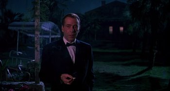 Movie still from “The Barefoot Contessa” (1954), directed by Joseph L. Mankiewicz – A man in a tuxedo standing in the dark holding a cigarette; Medium shot, Low angle