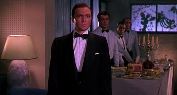 Movie still from “The Barefoot Contessa” (1954), directed by Joseph L. Mankiewicz – A man in a tuxedo standing in front of other men; Medium shot, Low angle