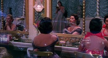 Movie still from “The Barefoot Contessa” (1954), directed by Joseph L. Mankiewicz – A woman is looking at herself in the mirror; Medium shot, High angle