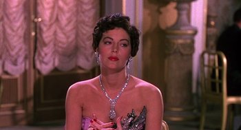 Movie still from “The Barefoot Contessa” (1954), directed by Joseph L. Mankiewicz – A woman wearing a necklace and earrings in a room; Close Up shot, Over the shoulder angle