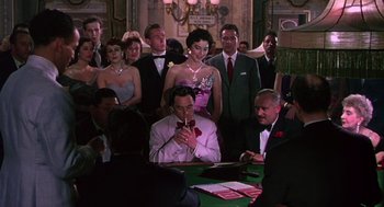 Movie still from “The Barefoot Contessa” (1954), directed by Joseph L. Mankiewicz – A group of people sitting at a table in a room; Medium shot, High angle